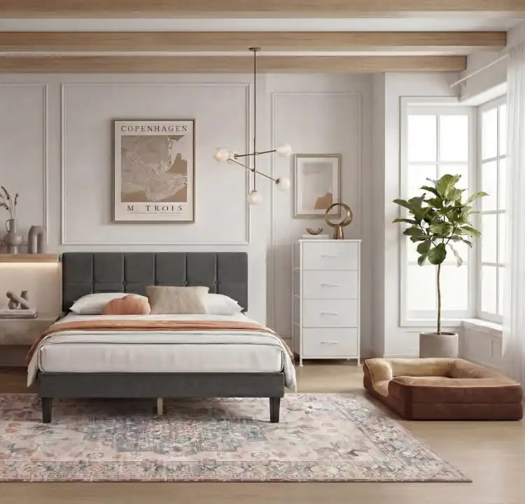 Modern bedroom with a gray upholstered bed, white dresser, and decorative elements.